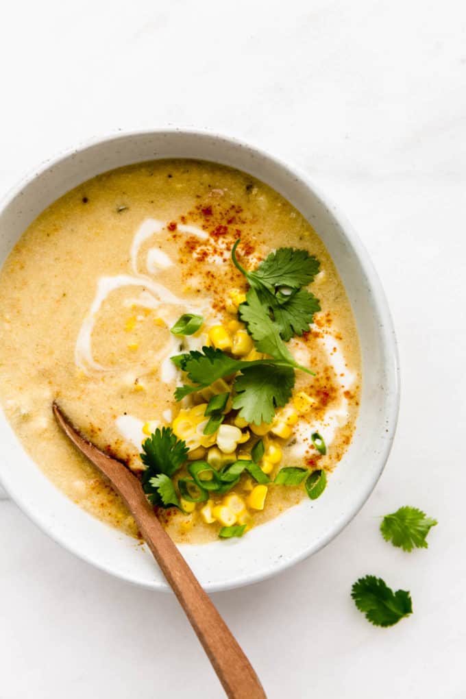 A bowl of vegan corn chowder topped with corn and cilantro