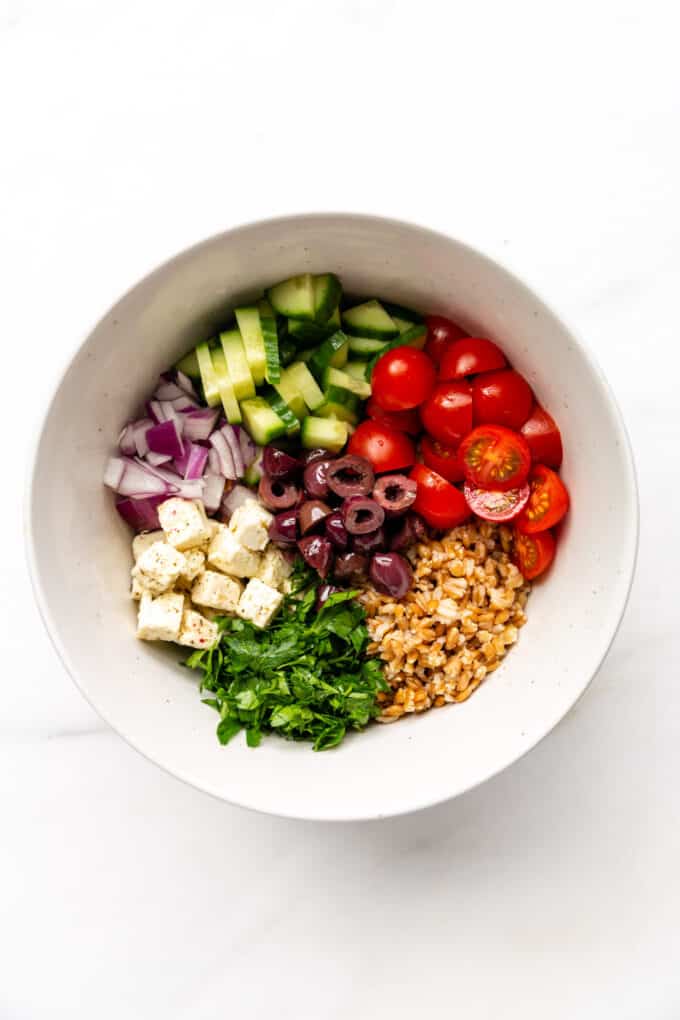 vegetables, farro and feta cheese in a salad bowl